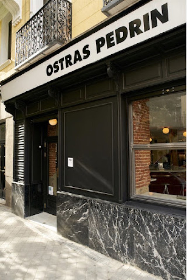 Black facade of Ostras Pedrín with its sign